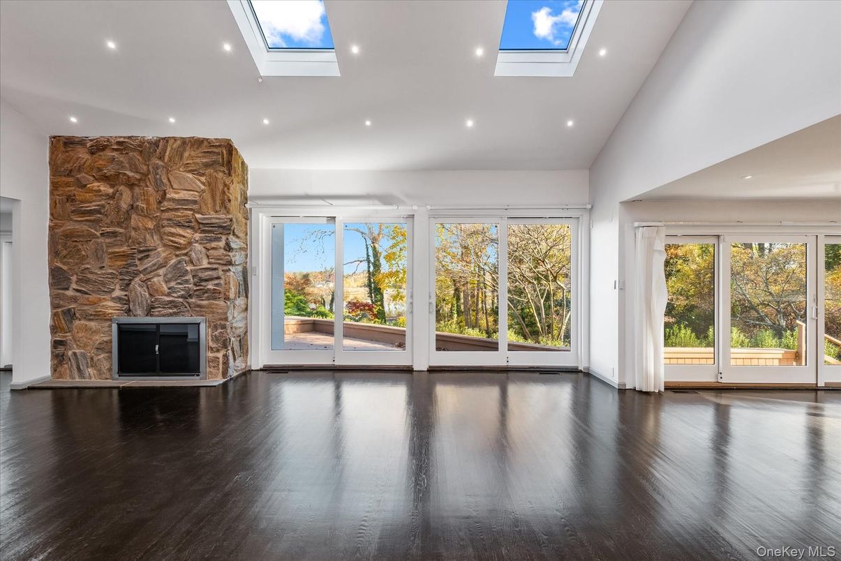 Empty room, Fireplace, Glass Ceilings, Interior, Recessed Lighting, Stone Walls, Sun Room, Wood Texture Flooring