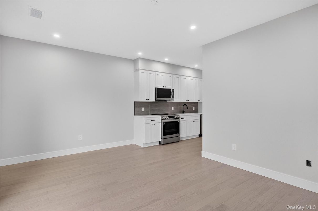 Empty room, Interior, Kitchen, Recessed Lighting, Stainless Steel Appliances, Wood Texture Flooring