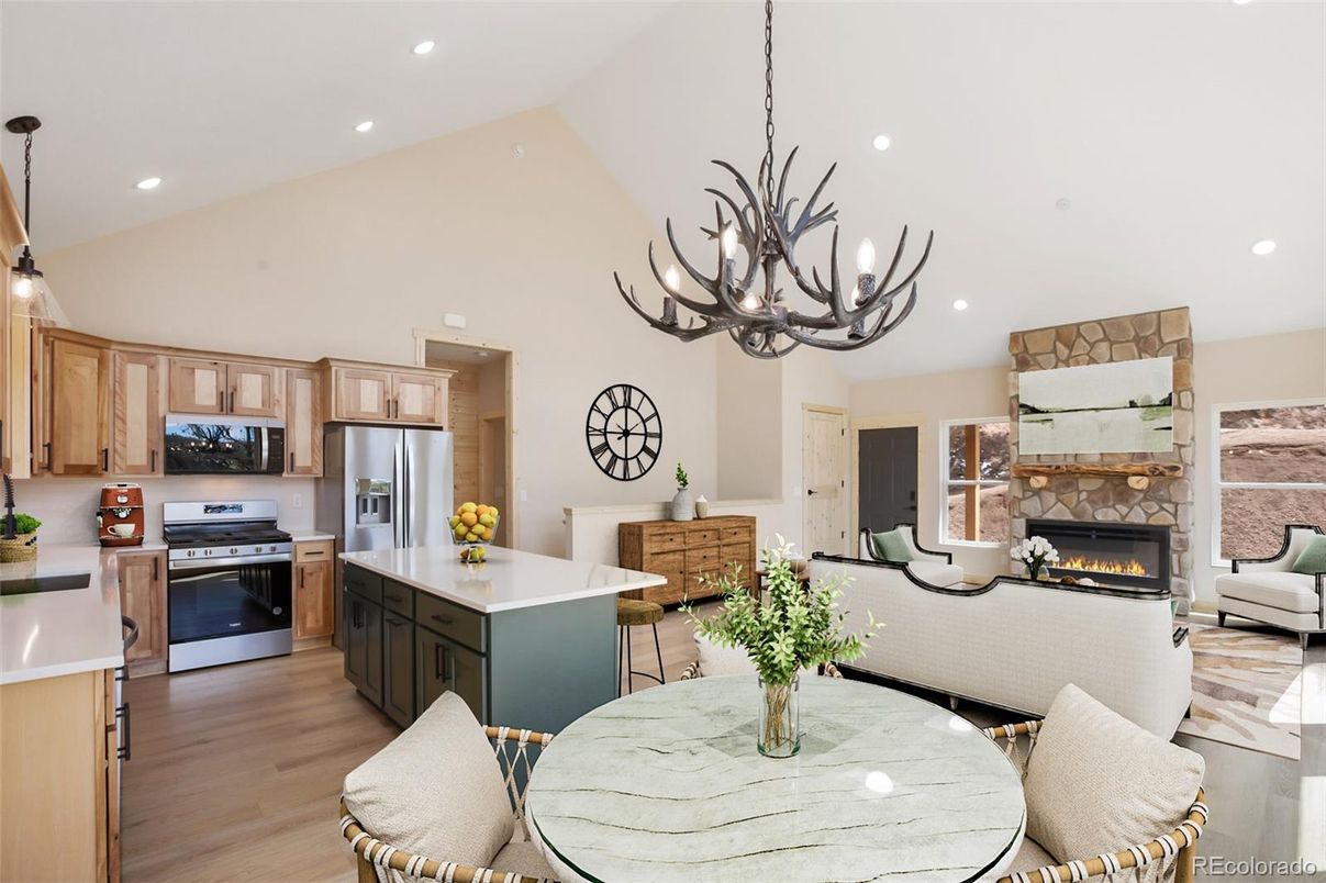 Chandelier, Fireplace, Interior, Kitchen, Living room, Pendant Lights, Recessed Lighting, Stainless Steel Appliances, Wood Texture Flooring