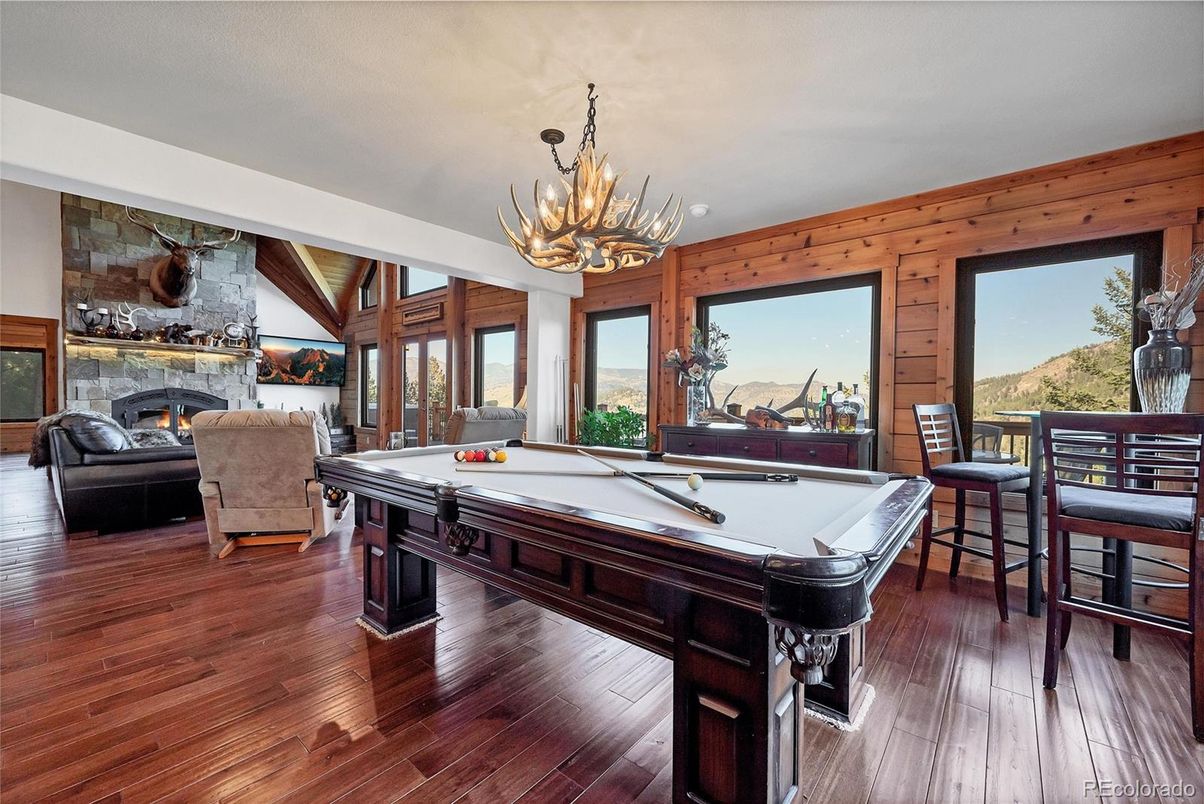 Billiard Table, Chandelier, Fireplace, Game Room, Interior, Living room, Stone Walls, Wood Texture Flooring, Wooden Walls