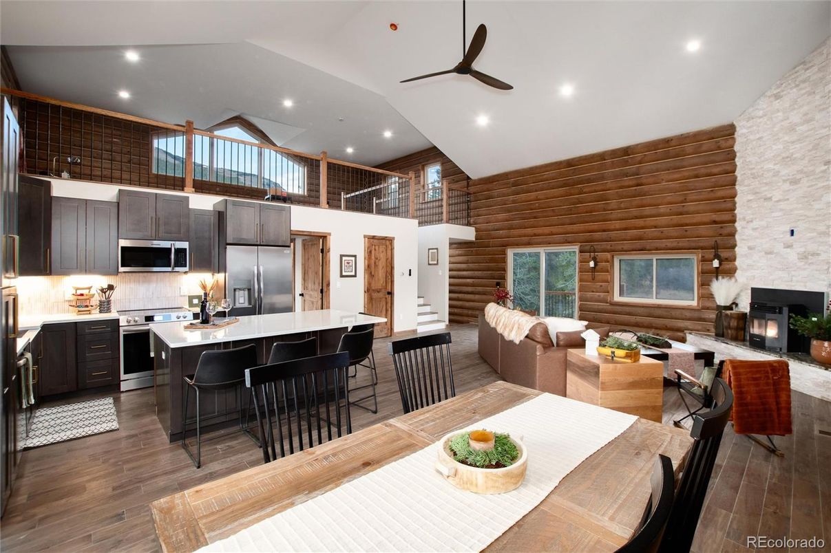 Dining room, Fireplace, Interior, Kitchen, Living room, Recessed Lighting, Stainless Steel Appliances, Wood Texture Flooring, Wooden Walls