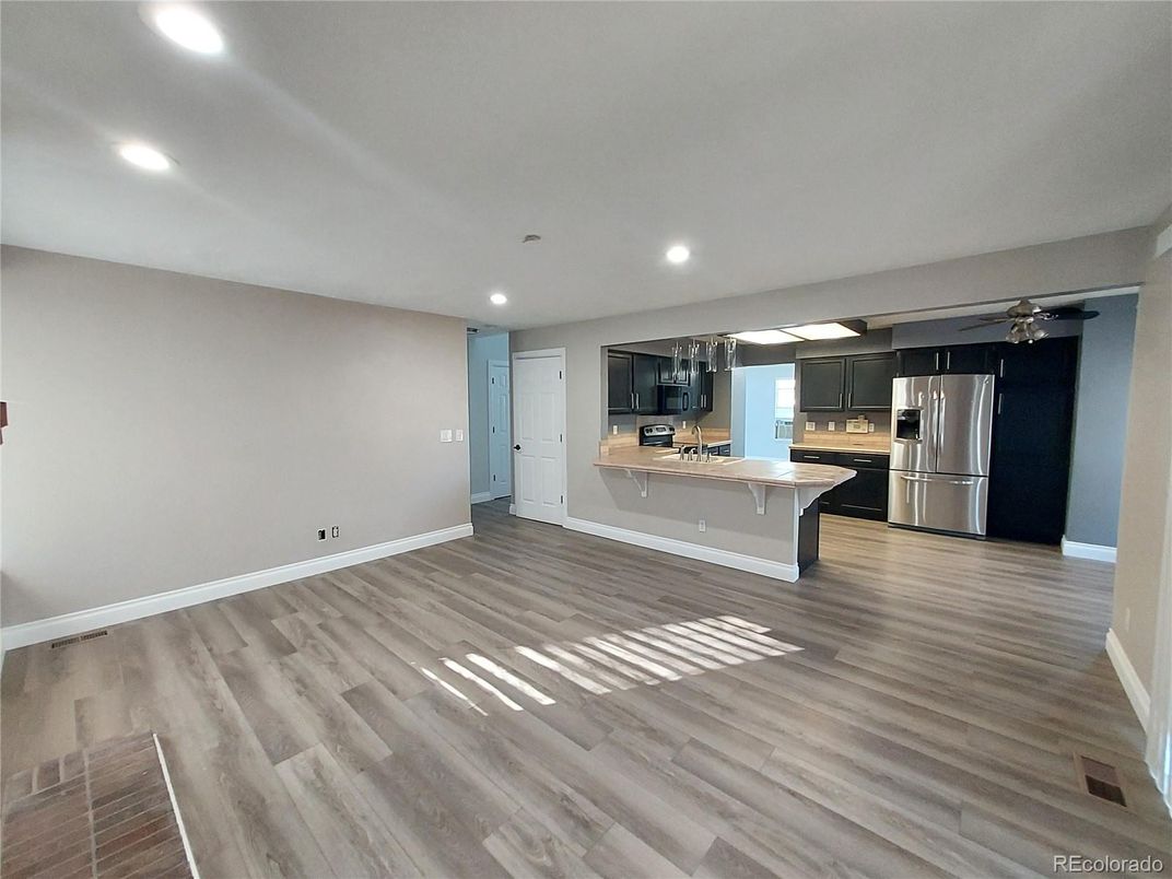 Empty room, Interior, Kitchen, Recessed Lighting, Stainless Steel Appliances, Wood Texture Flooring