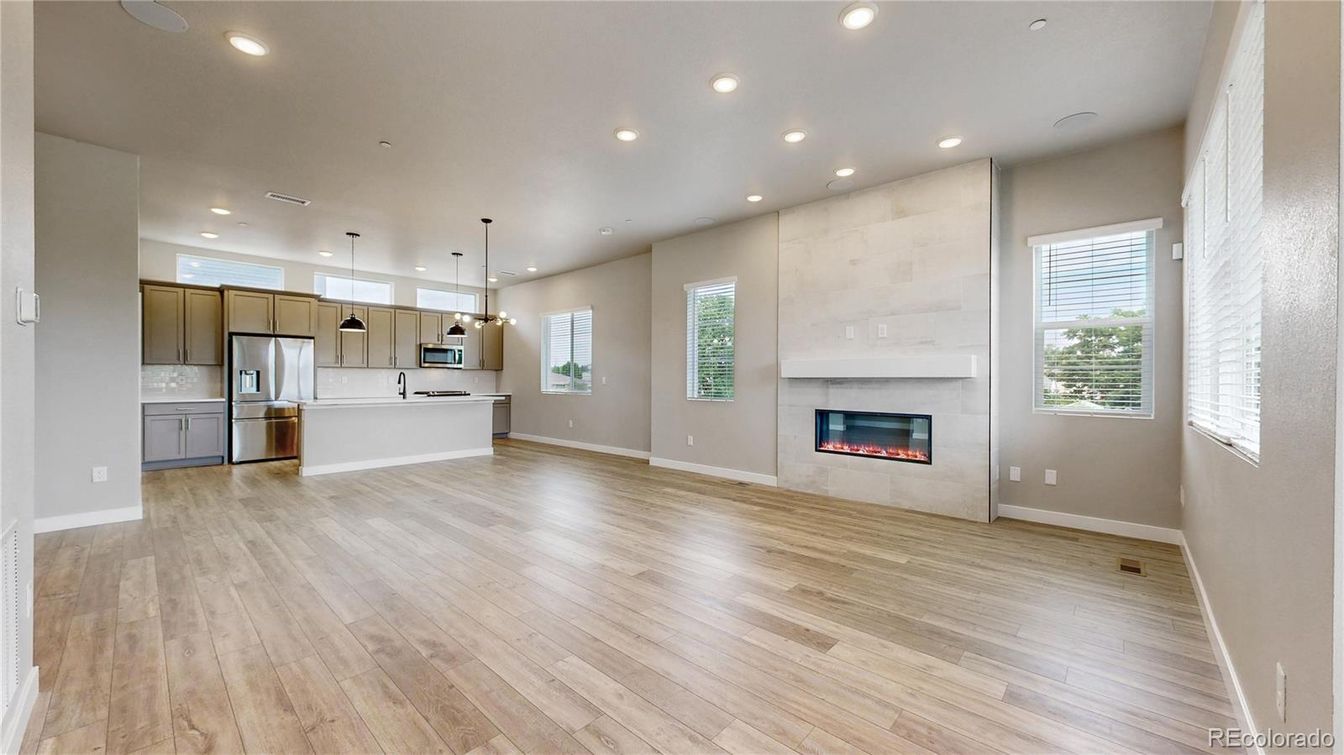 Empty room, Fireplace, Interior, Kitchen, Pendant Lights, Recessed Lighting, Stainless Steel Appliances, Wood Texture Flooring