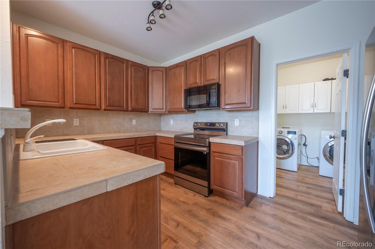 Interior, Kitchen, Tile Countertops, Washer, Wood Texture Flooring
