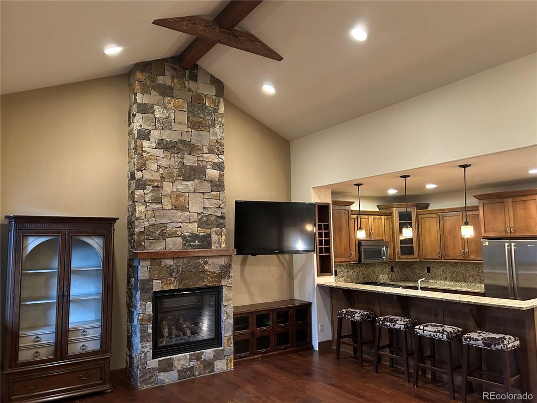 Fireplace, Interior, Kitchen, Pendant Lights, Recessed Lighting, Stainless Steel Appliances, Stone Walls, Wooden Beams, Wood Texture Flooring
