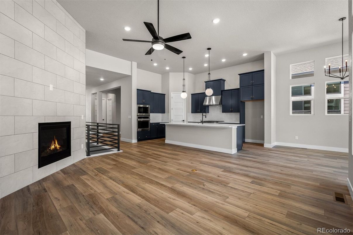 Empty room, Fireplace, Interior, Kitchen, Pendant Lights, Recessed Lighting, Stainless Steel Appliances, Wood Texture Flooring