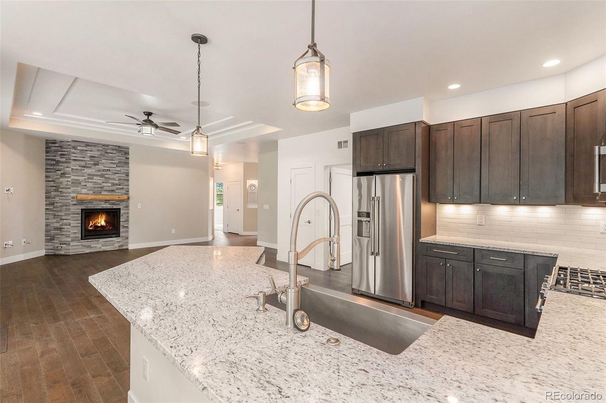 Fireplace, Interior, Kitchen, Pendant Lights, Recessed Lighting, Stainless Steel Appliances, Stone Walls, Wood Texture Flooring