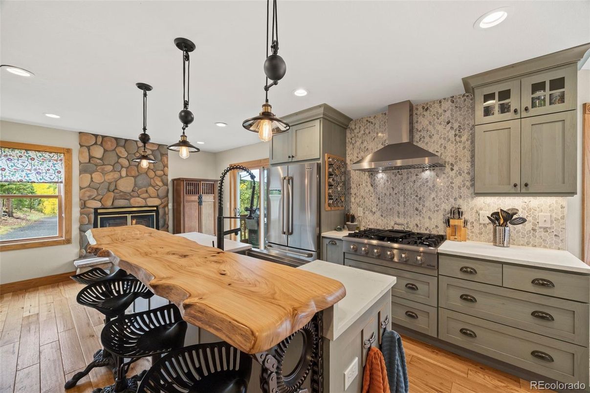 Fireplace, Interior, Kitchen, Pendant Lights, Recessed Lighting, Stainless Steel Appliances, Stone Walls, Wood Texture Flooring