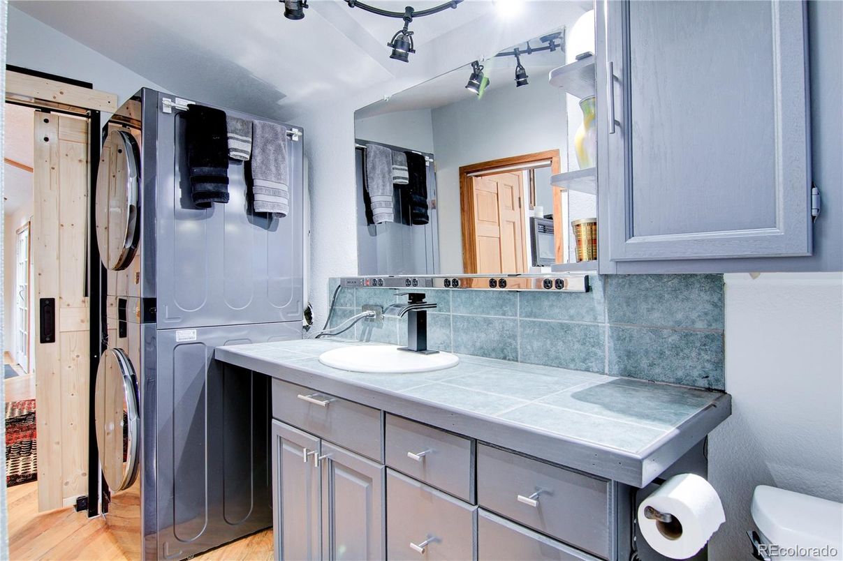Bathroom, Interior, Tile Countertops, Washer, Wood Texture Flooring