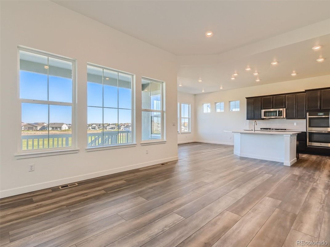 Empty room, Interior, Kitchen, Recessed Lighting, Stainless Steel Appliances, Wood Texture Flooring