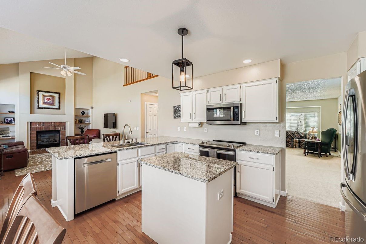 Fireplace, Interior, Kitchen, Living room, Pendant Lights, Recessed Lighting, Stainless Steel Appliances, Wood Texture Flooring