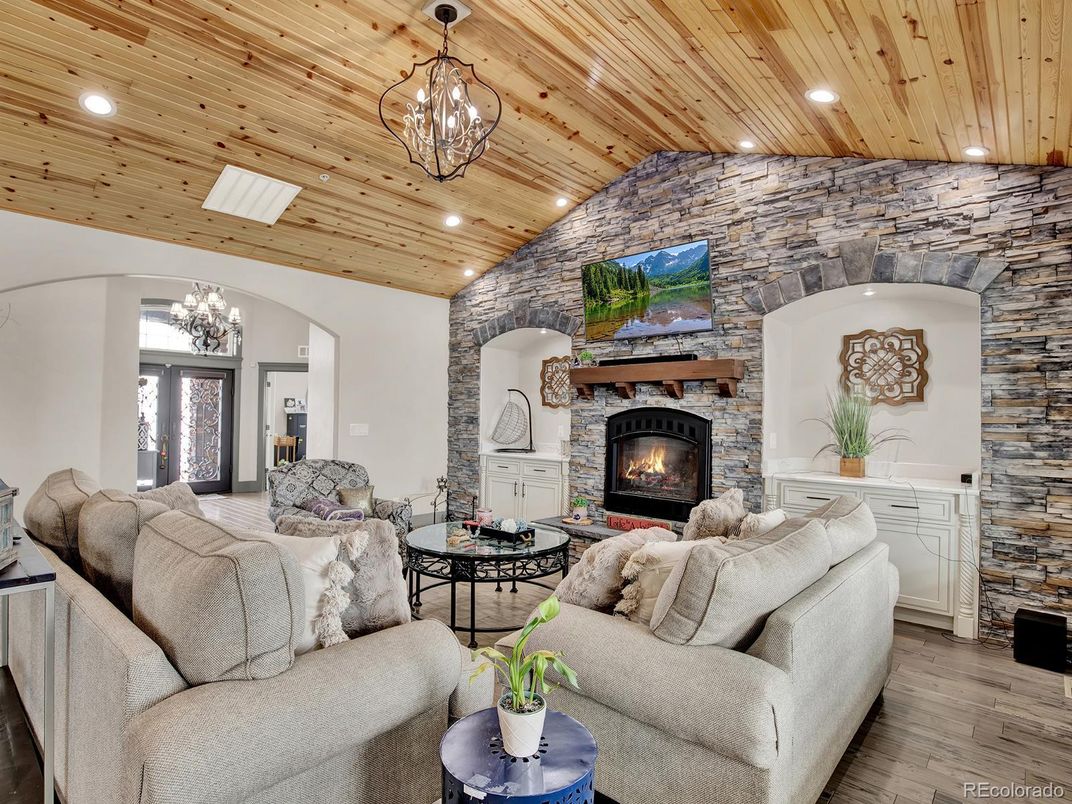 Chandelier, Fireplace, Interior, Living room, Recessed Lighting, Stone Walls, Wooden Ceilings, Wood Texture Flooring