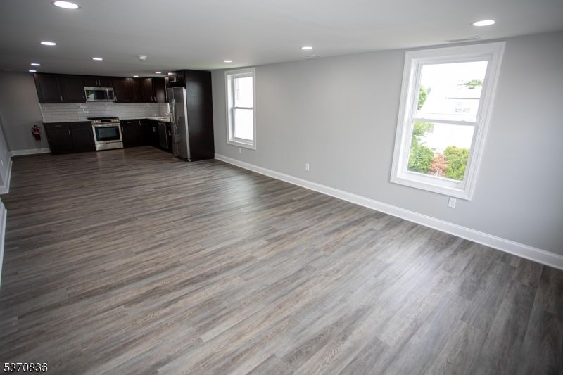 Empty room, Interior, Kitchen, Recessed Lighting, Stainless Steel Appliances, Wood Texture Flooring