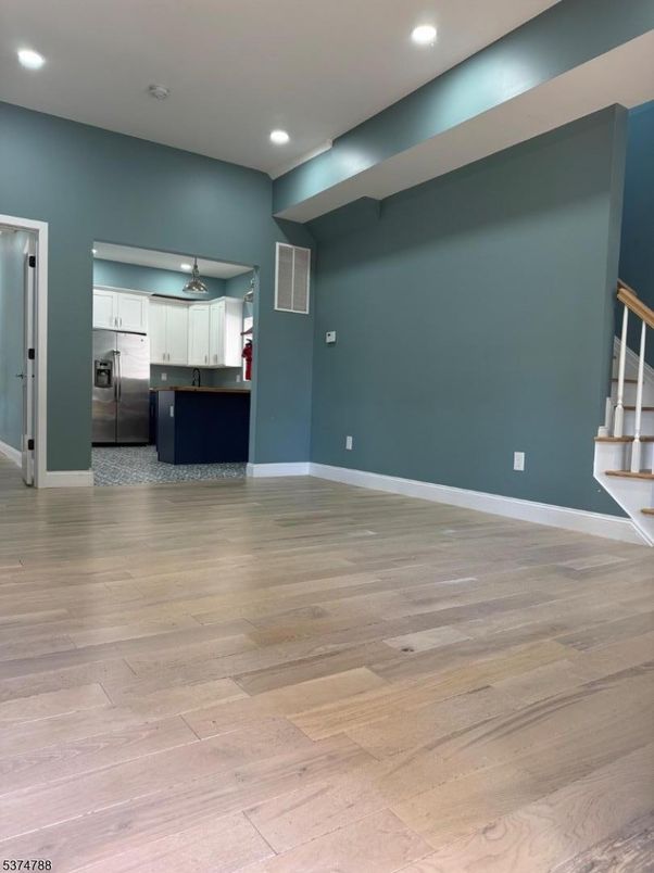 Empty room, Interior, Kitchen, Recessed Lighting, Stainless Steel Appliances, Wood Texture Flooring