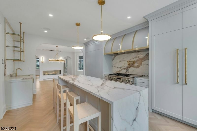 Fireplace, Interior, Kitchen, Marble Walls, Pendant Lights, Recessed Lighting, Stainless Steel Appliances, Wood Texture Flooring
