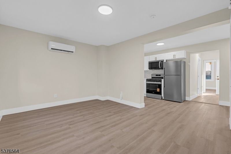 Empty room, Interior, Kitchen, Recessed Lighting, Stainless Steel Appliances, Wood Texture Flooring