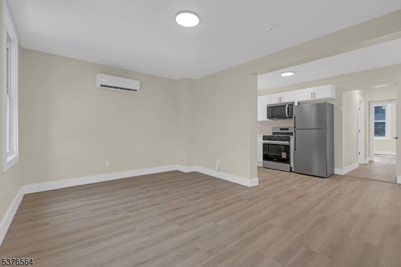Empty room, Interior, Kitchen, Recessed Lighting, Stainless Steel Appliances, Wood Texture Flooring
