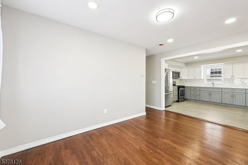 Empty room, Interior, Kitchen, Recessed Lighting, Stainless Steel Appliances, Wood Texture Flooring
