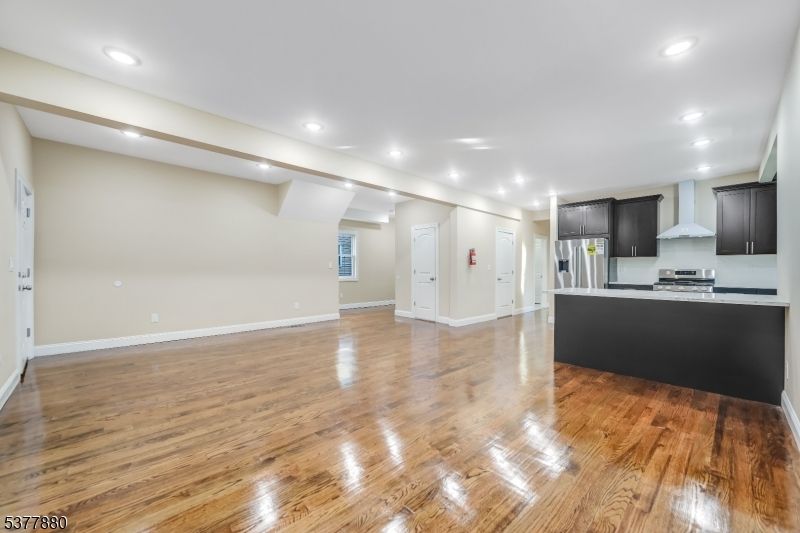 Empty room, Interior, Kitchen, Recessed Lighting, Stainless Steel Appliances, Wood Texture Flooring