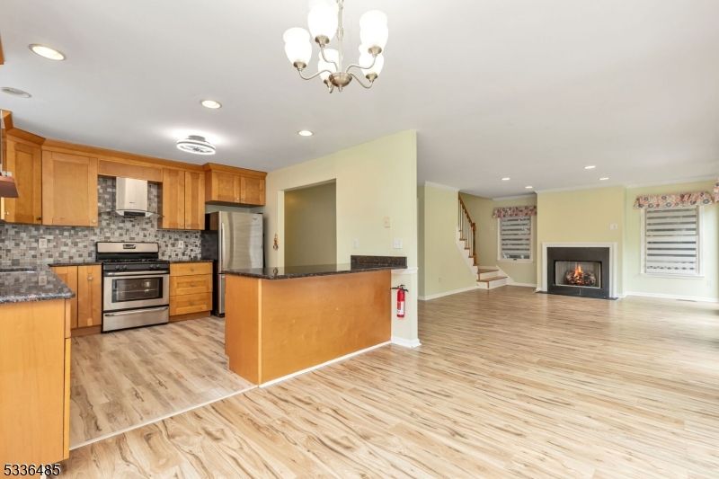 Chandelier, Fireplace, Interior, Kitchen, Recessed Lighting, Stainless Steel Appliances, Wood Texture Flooring