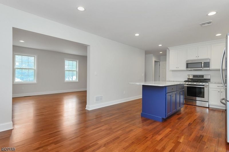 Empty room, Interior, Kitchen, Recessed Lighting, Stainless Steel Appliances, Wood Texture Flooring