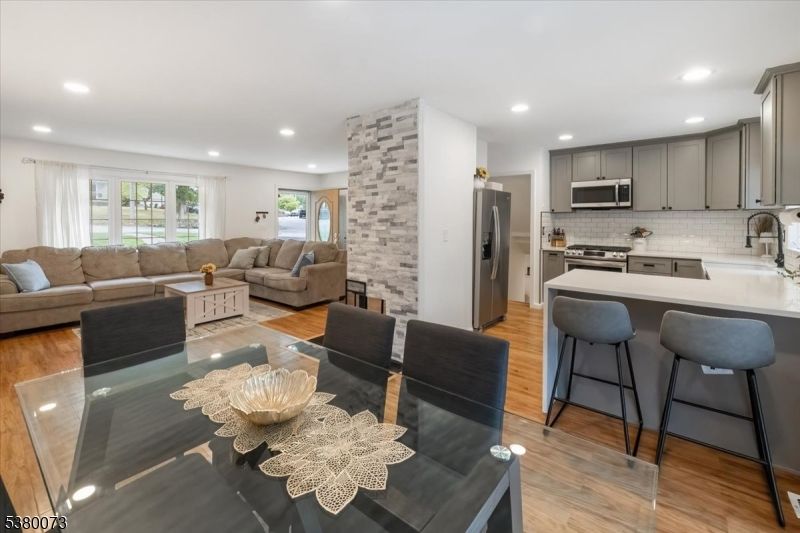 Dining room, Fireplace, Interior, Kitchen, Living room, Recessed Lighting, Stainless Steel Appliances, Stone Walls, Wood Texture Flooring