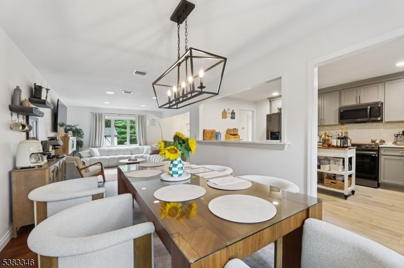 Chandelier, Dining room, Interior, Kitchen, Living room, Pendant Lights, Recessed Lighting, Stainless Steel Appliances, Wood Texture Flooring