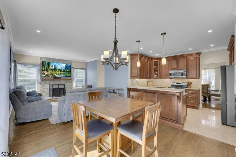 Chandelier, Dining room, Fireplace, Interior, Kitchen, Living room, Pendant Lights, Recessed Lighting, Stainless Steel Appliances, Wood Texture Flooring