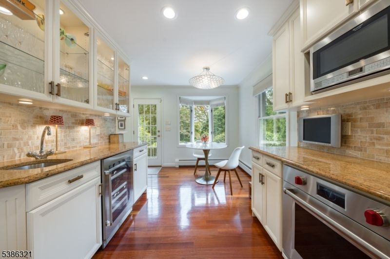 Chandelier, Dining room, Interior, Kitchen, Recessed Lighting, Stainless Steel Appliances, Stone Walls, Wood Texture Flooring