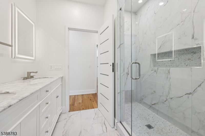 Bathroom, Dual Sink Vanities, Glass Shower, Interior, Marble, Marble Walls, Recessed Lighting, Wood Texture Flooring