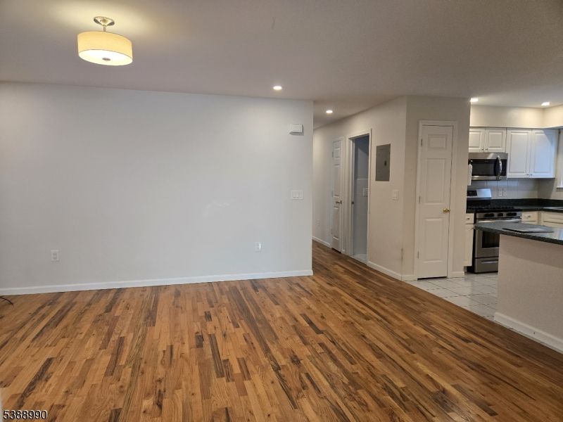 Empty room, Interior, Kitchen, Recessed Lighting, Stainless Steel Appliances, Wood Texture Flooring