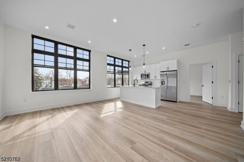 Empty room, Interior, Kitchen, Pendant Lights, Recessed Lighting, Stainless Steel Appliances, Wood Texture Flooring