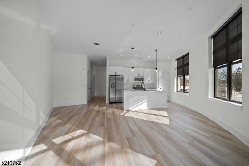 Empty room, Interior, Kitchen, Pendant Lights, Recessed Lighting, Stainless Steel Appliances, Wood Texture Flooring