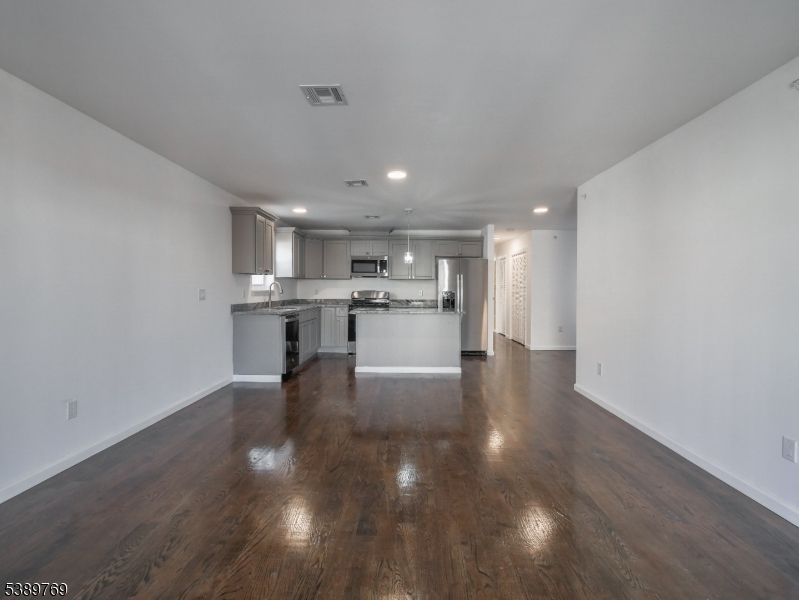 Empty room, Interior, Kitchen, Recessed Lighting, Stainless Steel Appliances, Wood Texture Flooring