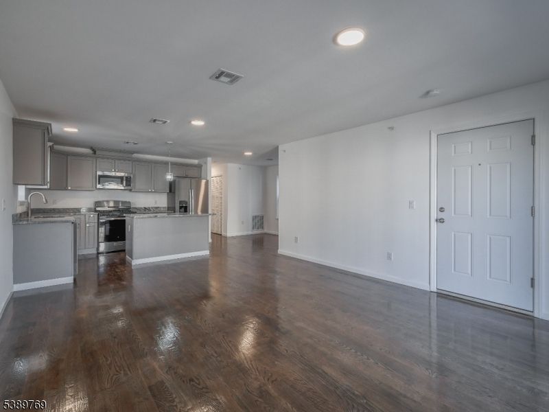 Empty room, Interior, Kitchen, Recessed Lighting, Stainless Steel Appliances, Wood Texture Flooring