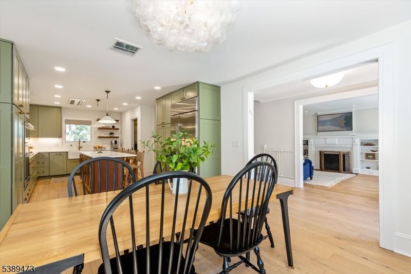 Chandelier, Dining room, Fireplace, Interior, Kitchen, Pendant Lights, Recessed Lighting, Stainless Steel Appliances, Wood Texture Flooring