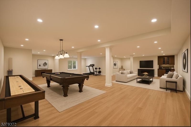 Billiard Table, Fireplace, Fitness Equipment, Game Room, Interior, Living room, Pendant Lights, Recessed Lighting, Wood Texture Flooring