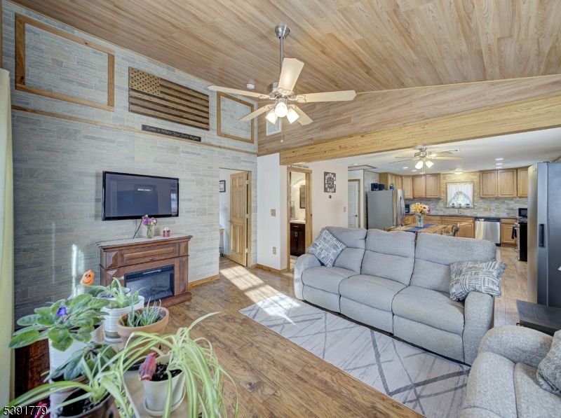 Fireplace, Interior, Kitchen, Living room, Recessed Lighting, Stainless Steel Appliances, Stone Walls, Wooden Ceilings, Wood Texture Flooring