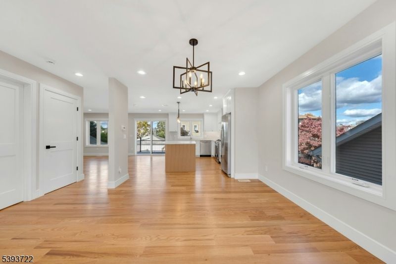 Empty room, Interior, Kitchen, Pendant Lights, Recessed Lighting, Stainless Steel Appliances, Wood Texture Flooring