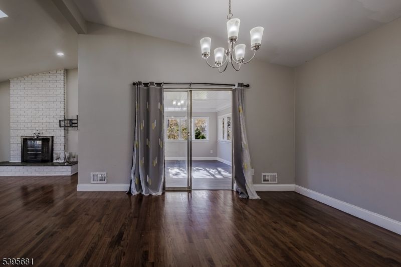 Chandelier, Empty room, Fireplace, Interior, Recessed Lighting, Stone Walls, Wood Texture Flooring