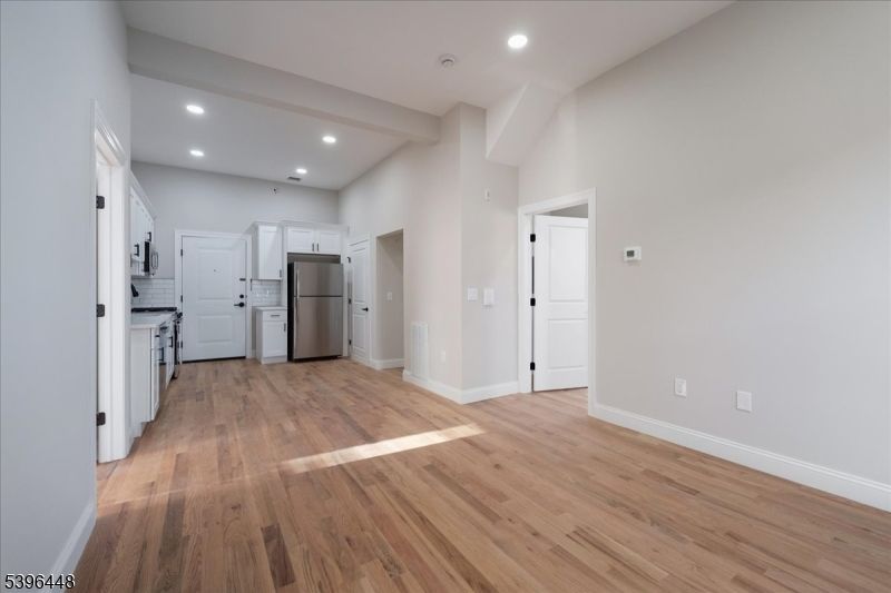 Empty room, Interior, Kitchen, Recessed Lighting, Stainless Steel Appliances, Wood Texture Flooring