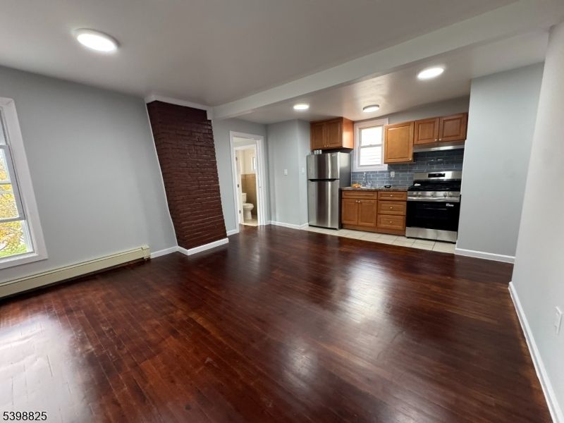 Empty room, Interior, Kitchen, Recessed Lighting, Stainless Steel Appliances, Wood Texture Flooring