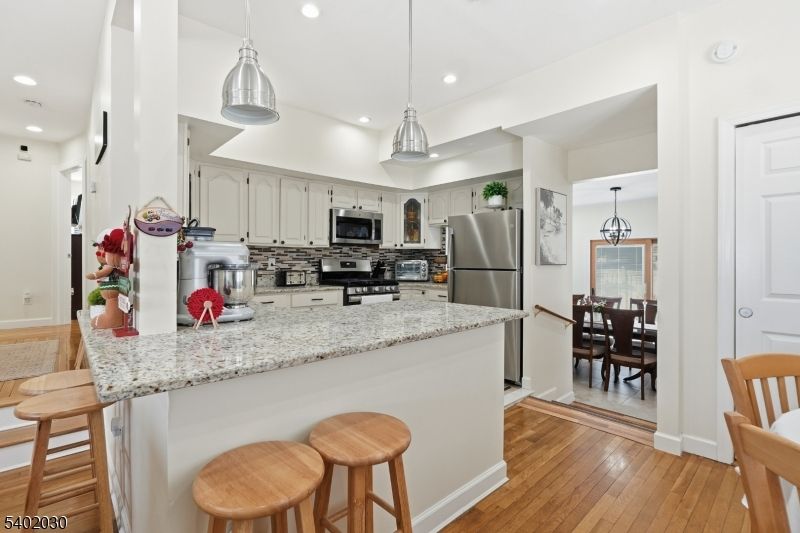Dining room, Interior, Kitchen, Pendant Lights, Recessed Lighting, Stainless Steel Appliances, Wood Texture Flooring