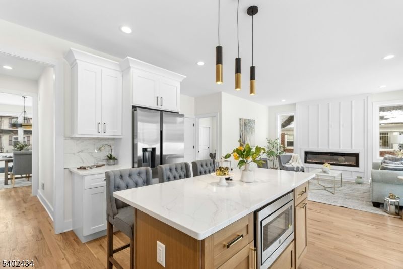 Dining room, Fireplace, Interior, Kitchen, Living room, Pendant Lights, Recessed Lighting, Stainless Steel Appliances, Wood Texture Flooring