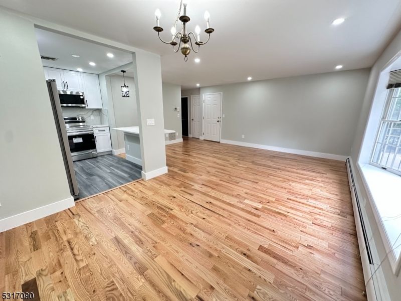 Chandelier, Empty room, Interior, Kitchen, Recessed Lighting, Stainless Steel Appliances, Wood Texture Flooring