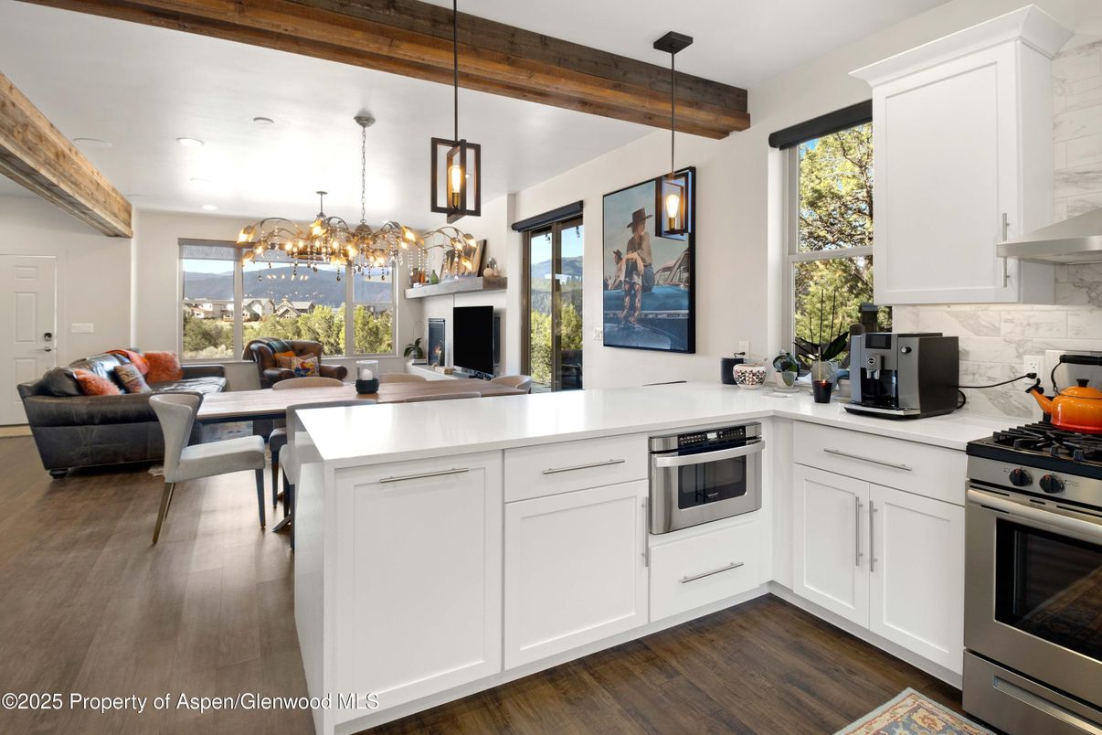 Chandelier, Dining room, Interior, Kitchen, Living room, Pendant Lights, Recessed Lighting, Stainless Steel Appliances, Wooden Beams, Wood Texture Flooring