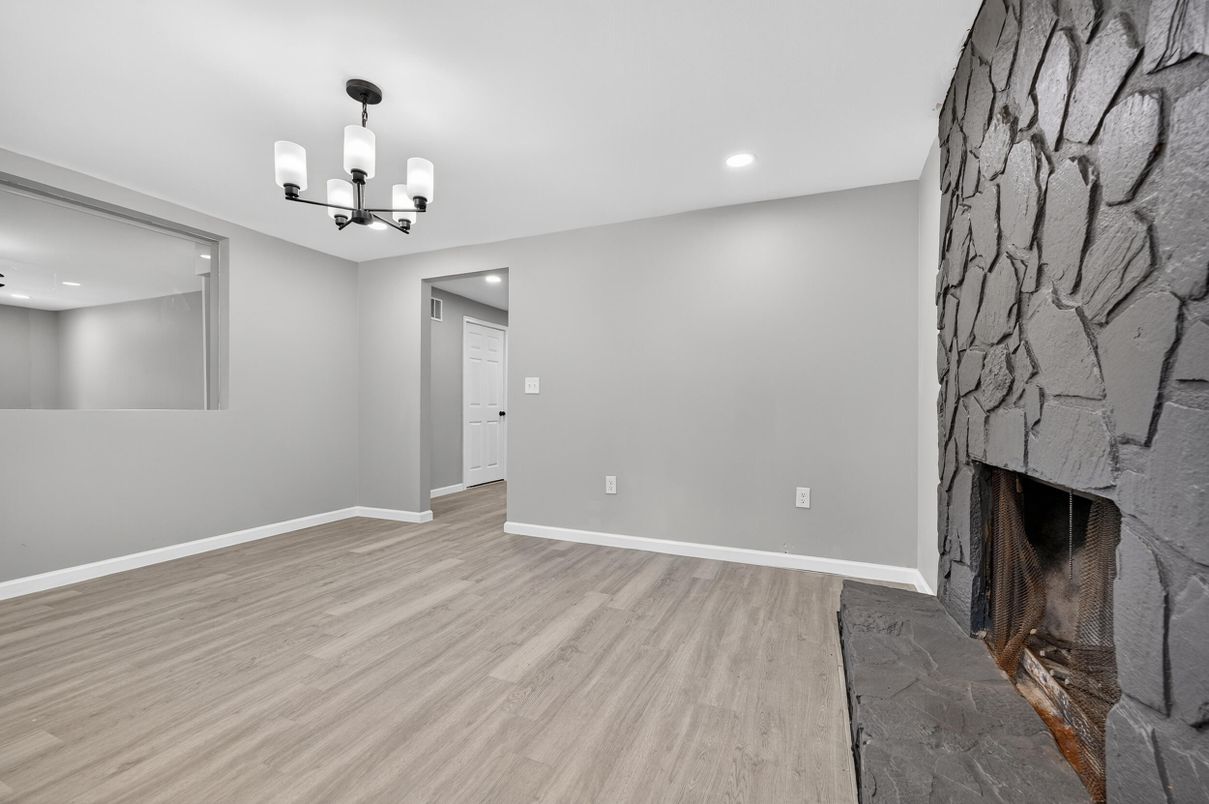 Chandelier, Empty room, Fireplace, Interior, Recessed Lighting, Stone Walls, Wood Texture Flooring