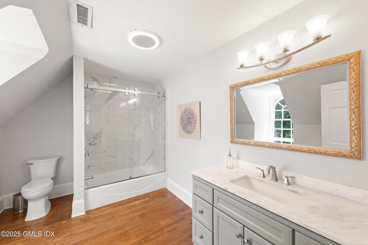 Bathroom, Dual Sink Vanities, Glass Shower, Interior, Marble Walls, Recessed Lighting, Wood Texture Flooring