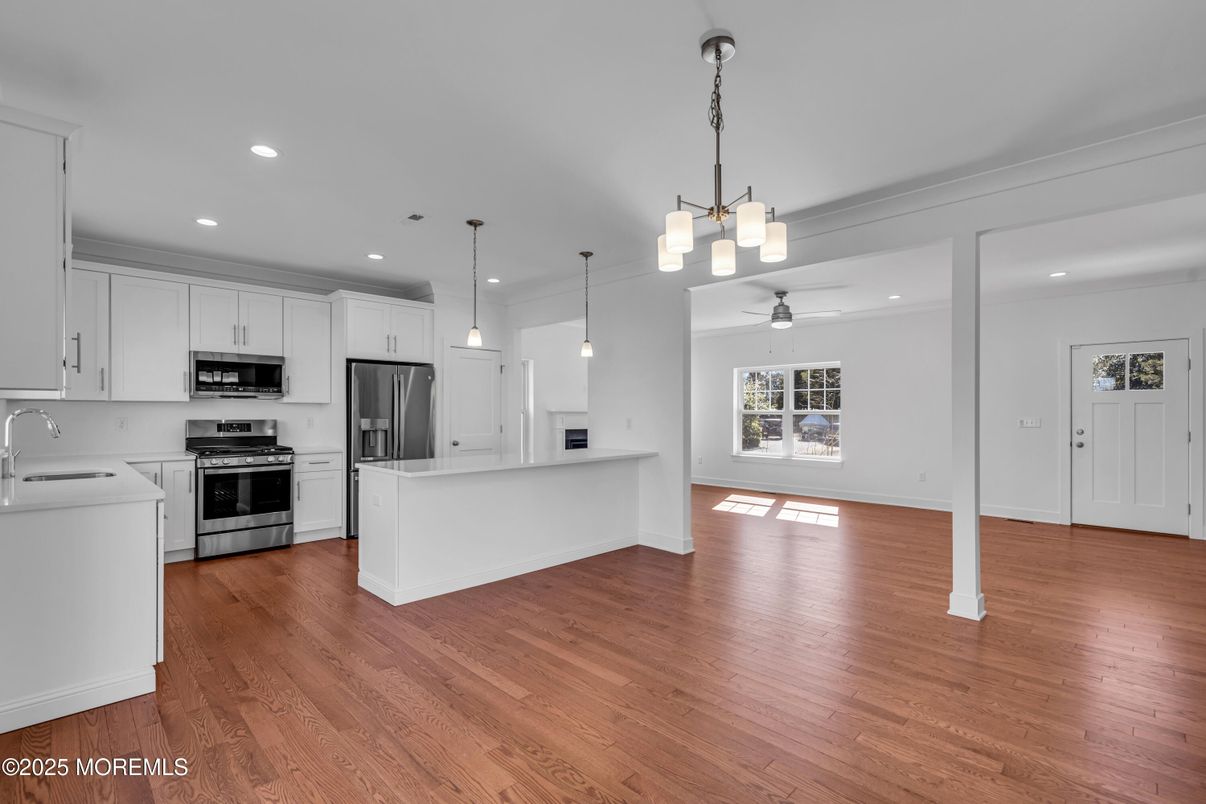 Empty room, Interior, Kitchen, Pendant Lights, Recessed Lighting, Stainless Steel Appliances, Wood Texture Flooring