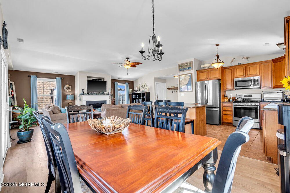 Chandelier, Dining room, Fireplace, Interior, Kitchen, Living room, Pendant Lights, Stainless Steel Appliances, Wood Texture Flooring